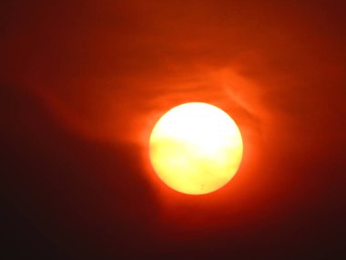 Gökyüzünde gün batımı, kırmızı ve turuncu, fotoğrafa yakın.