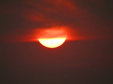 Gökyüzünde gün batımı, kırmızı ve turuncu, fotoğrafa yakın.