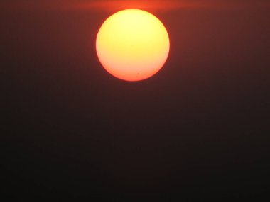 Gökyüzünde gün batımı, kırmızı ve turuncu, fotoğrafa yakın.