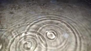 Yere yağmur suyu yağıyor. Su sıçratma detay gibi görünüyor.
