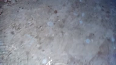 Yere yağmur suyu yağıyor. Su sıçratma detay gibi görünüyor.