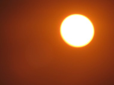 Gökyüzünde gün batımı kızıl bir güneşle