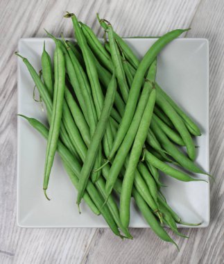 Tahta masadaki yeşil fasulyeler.