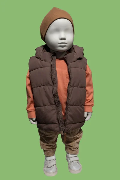全长图像显示一个孩子穿着温暖的棉被背心和灯芯绒在绿色背景上隔离的人体模特 — 图库照片