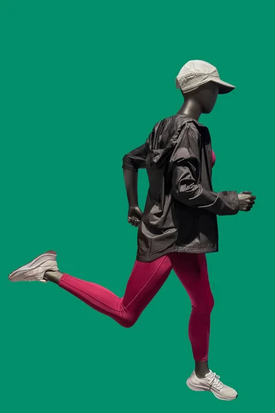 Afbeelding Van Een Lopende Vrouwelijke Etalagepop Dragen Sportkleding Geïsoleerd Groen — Stockfoto