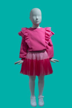 Kırmızı dantel bluz ve yeşil arka planda izole edilmiş etek giyen bir çocuk mankeninin tam boy görüntüsü