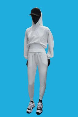 Mavi arka planda izole edilmiş zarif bir spor giysi giyen bir kadın vitrin mankeni.