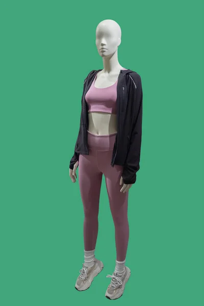 緑の背景に隔離されたスポーツウェアを身に着けている女性ディスプレイマネキンの完全な長さの画像 — ストック写真
