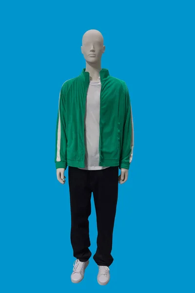 青い背景に隔離された緑のジップアップフリースジャケットと黒のズボンを身に着けている男性ディスプレイマネキンの完全な長さの画像 — ストック写真