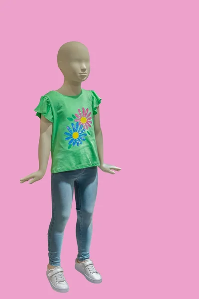ピンクの背景に多色の花を持つ緑のTシャツを着た子供ディスプレイマネキンの完全な長さの画像 — ストック写真