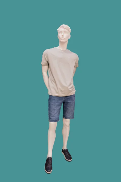 身穿灰色T恤和蓝色牛仔裤短裤的男装模特在绿色背景下被隔离的全长图像 — 图库照片