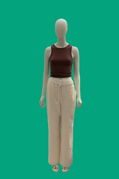 全长的女性形象展示人体模特穿着夏天流行的衣服与棕色无袖上衣和米色裤子 被绿色背景隔离 — 图库照片