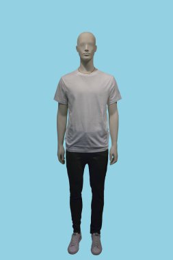 Full length image of a male display mannequin wearing white t-shirt and black trousers isolated on blue background