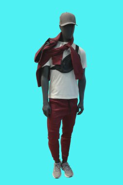 Mavi arka planda kırmızı kapüşonlu ve eşofmanlı bir erkek vitrin mankeni.