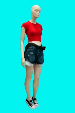 Kırmızı örülmüş üst ve mavi yırtık kot şort giyen yeşil arka plan izole bir kadın vitrin mankeni tam boy görüntüsü