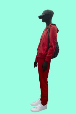 Yeşil arkaplanda izole edilmiş kırmızı spor elbise giyen bir posta vitrin mankeninin tam boy resmi
