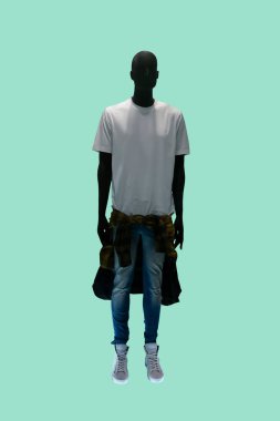 Full length image of a male display mannequin wearing white t-shirt and blue jeans isolated on green background