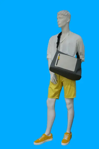 stock image Full length image of a male display mannequin wearing white collarless shirt and yellow shorts isolated on blue background