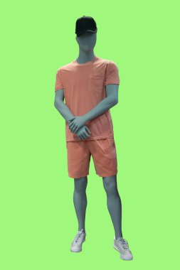 Yeşil arka planda izole edilmiş şık spor giysiler giyen bir erkek vitrin mankeni.