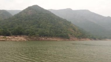 Çalı bir tepenin hareket kısa klip, üzerinde sisli dağlar ve yeşil okyanus yatıyordu