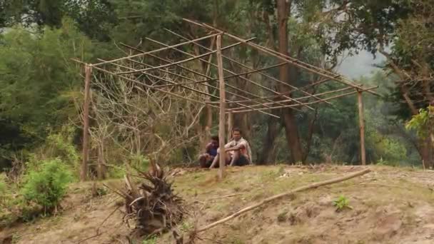 Два Чоловіки Сидять Під Тінню Дерев Яного Табору — стокове відео