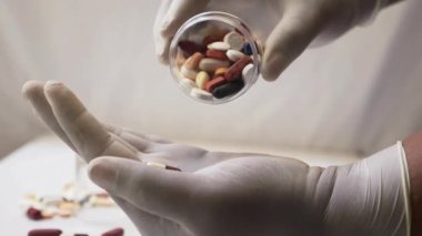 Birinin eline bir avuç hap dökerken yakın plan.