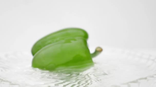 Padající Zelená Capsicum Bílé Vodě Skleněná Deska — Stock video