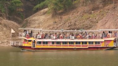 Hareket halindeki bir feribotun, yolcuların ve arkadaki tepelerin temiz kısa klipleri.