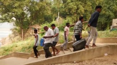 Erkekler merdivenleri tırmanıyor, iki adam ayakta.