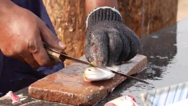 魚の鋭い側面をカットするためにナイフを使用して魚の売り手 — ストック動画