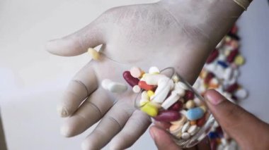 Birinin eline bir avuç hap dökerken yakın plan.