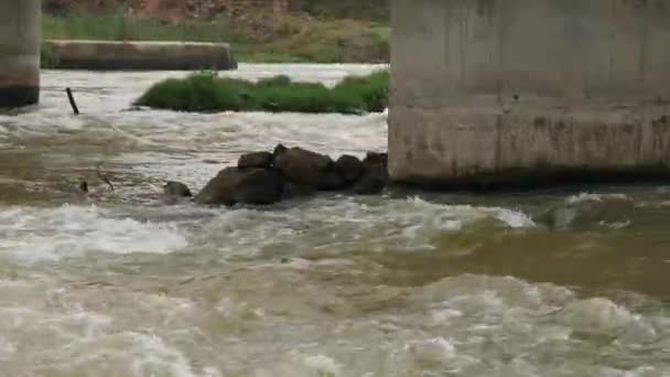 在奔流的河水中 有4K角形的大柱子和岩石被捕获 — 图库视频影像