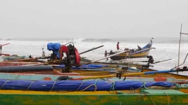 Männer Schieben Ein Boot Ins Meer Andere Fischerboote Parken Ufer — Stockvideo