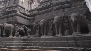 Merdivenlerin üstündeki Ellora mağaralarının dışında fil resimleri.