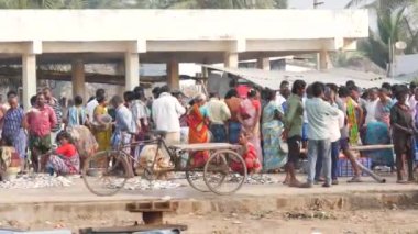 Bisikletler arkada, birçok insan balık pazarında iş yapmak için toplandı.