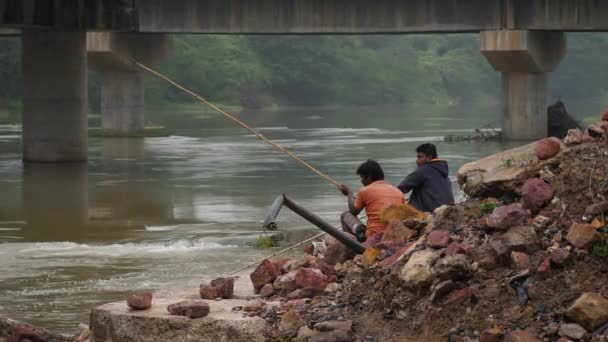 Dois Homens Sentados Rochas Segurando Varas Pesca Junto Rio — Vídeo de Stock