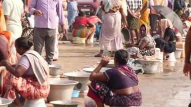 Balık satıcıları ellerinde balık ve alıcılarıyla oturmuş pazarlık ediyorlar - Chirala Balık Pazarı, AP, Hindistan - Aralık 2022