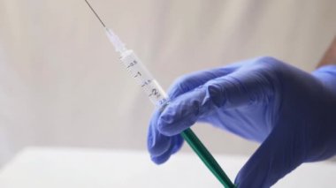 hand in glove with syringe close up