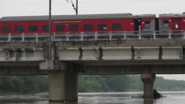 红色长列火车在桥上在水面上行驶的一小段镜头 — 图库视频影像
