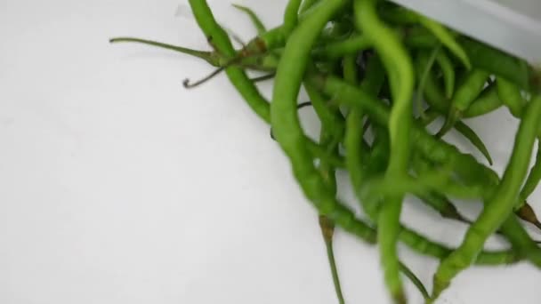 Fallende Grüne Chilischoten Vor Weißem Hintergrund — Stockvideo
