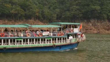 Yolcularla dolu uzun bir feribotun kamera görüntüleri.