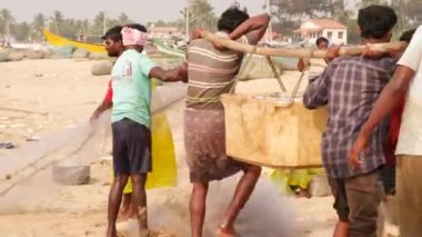 Balıkları sınıflandıran adamlar, sopayla sandık taşıyan adamlar, dik dik bakan kadınlar.