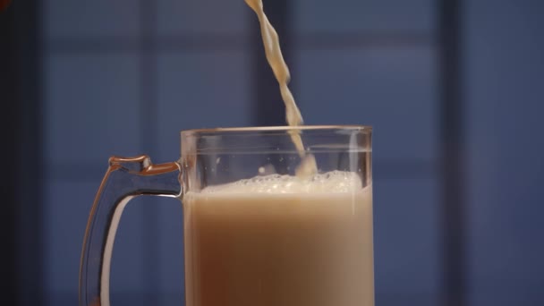 牛乳はグラスとマグカップに注ぎ込まれ 爽やかな飲み物を作る — ストック動画