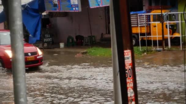 一辆汽车驶过被水淹没的街道 一辆红色的汽车驶过被洪水淹没的街道 — 图库视频影像
