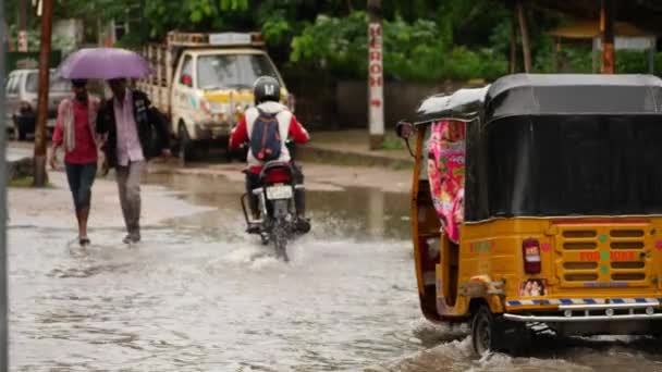 黄色いトゥクトゥクと通りで洪水をナビゲートするオートバイの人 — ストック動画