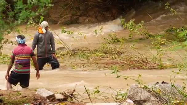 Ein Mann Und Eine Frau Gehen Durch Einen Schlammigen Fluss — Stockvideo