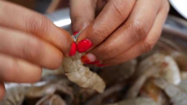 一个女人的手拿着一颗白珍珠女人的手把虾仁放进碗里持鱼的人 — 图库视频影像