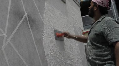 Professional Painter Applying White Paint to Wall