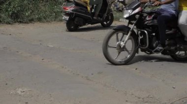 Two People Riding a Motorcycle on a Dirt Road