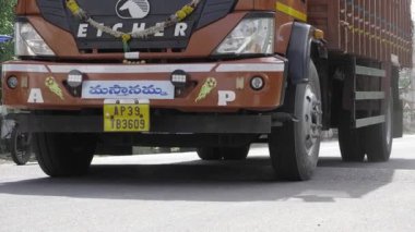 Vibrant Indian Truck on the Move, A close-up of the front of a red truck.